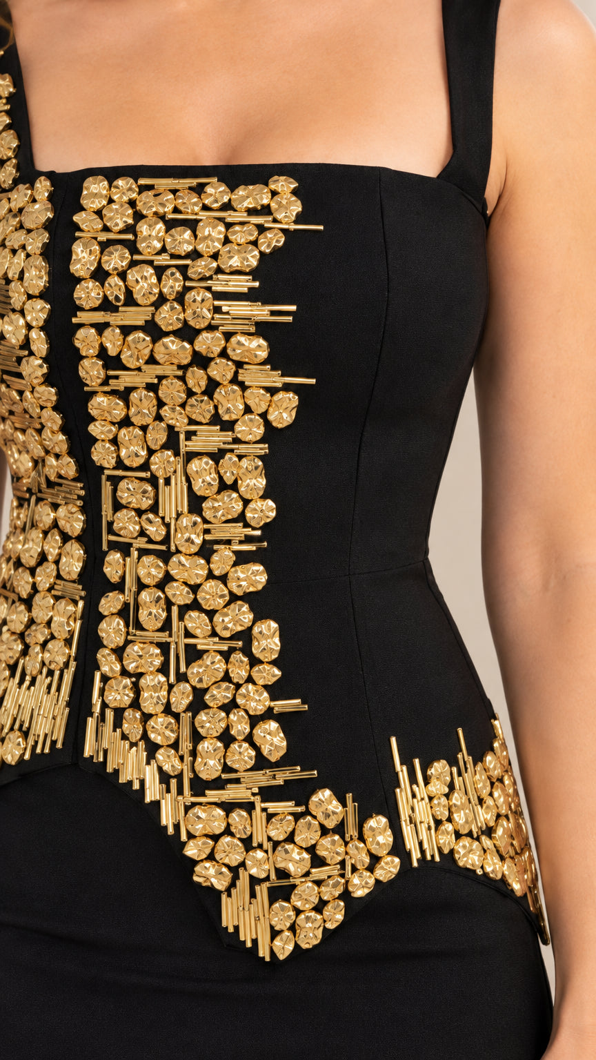 Close-up detail of textured gold bead and sequin embellishment on black bodice