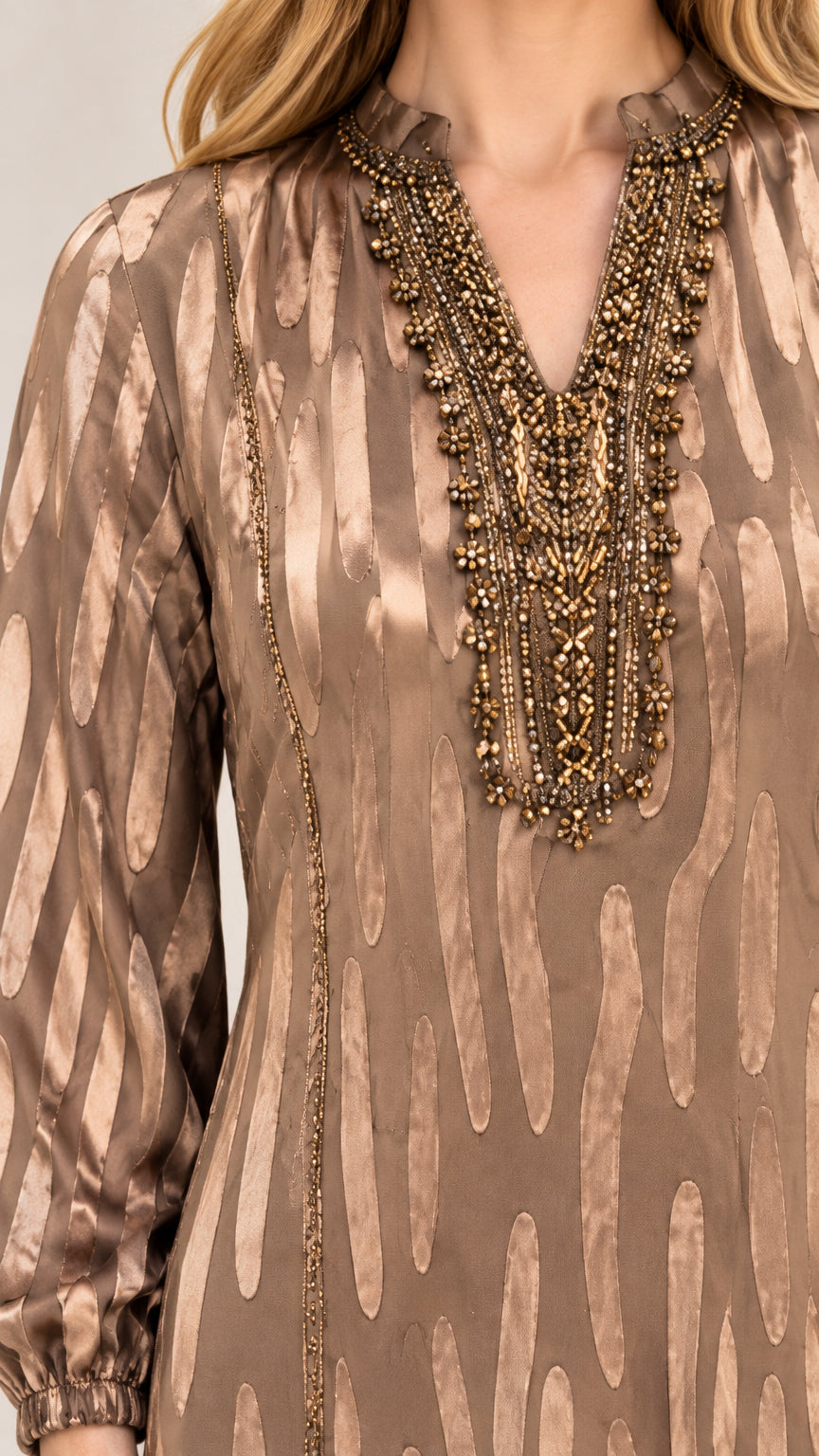 Close-up detail of intricate metallic beading along the V-neckline