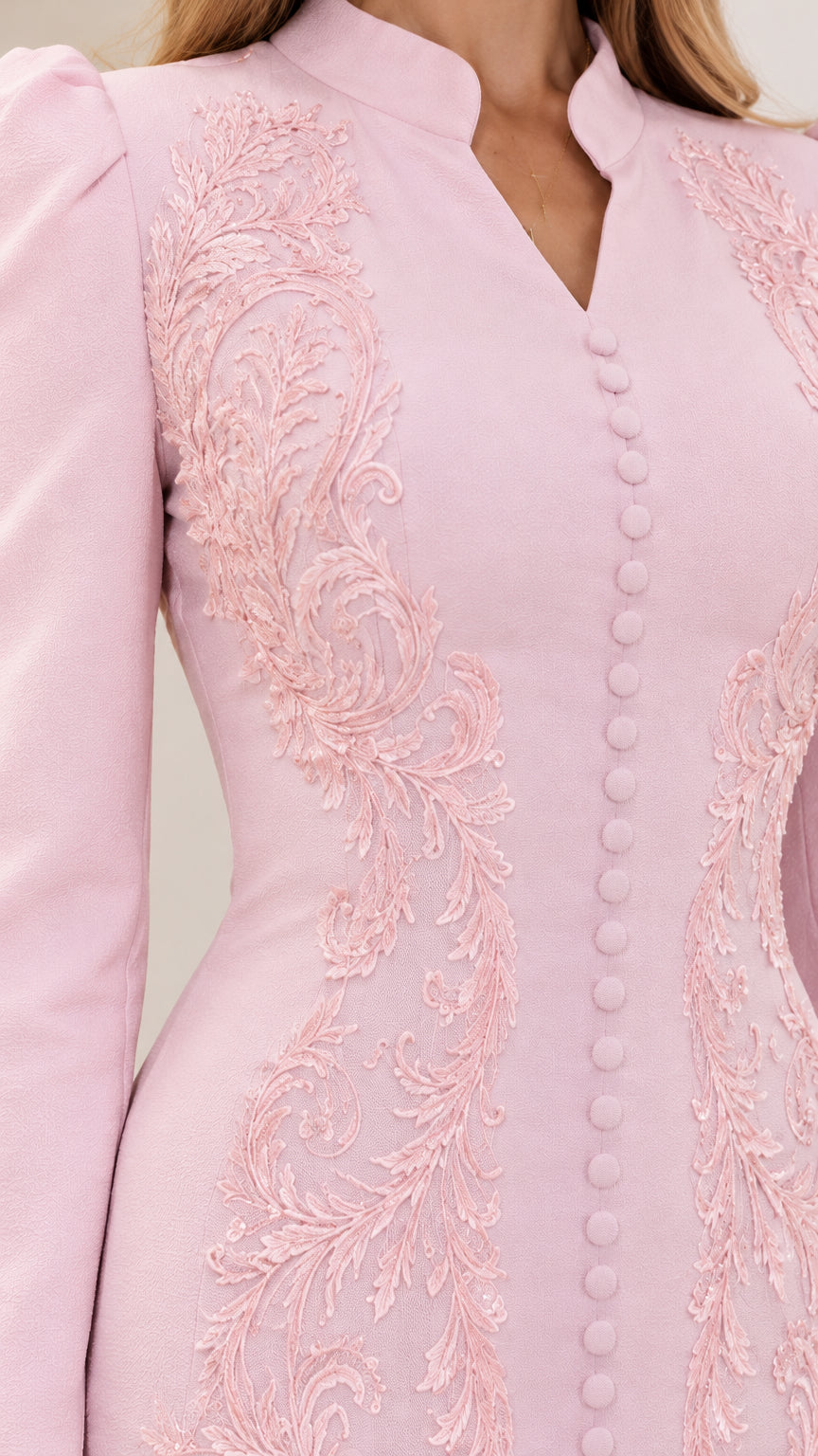 Close-up detail of bodice embroidery and covered buttons on light pink gown