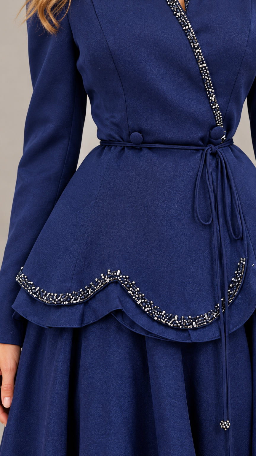 Close-up detail of beaded trim and tie waist on Navy Blue peplum bodice