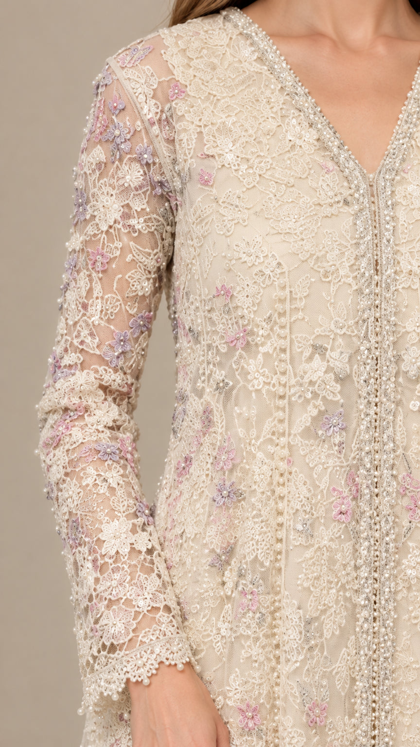 Close-up detail of cream embroidered lace fabric with delicate floral embroidery and beaded trim