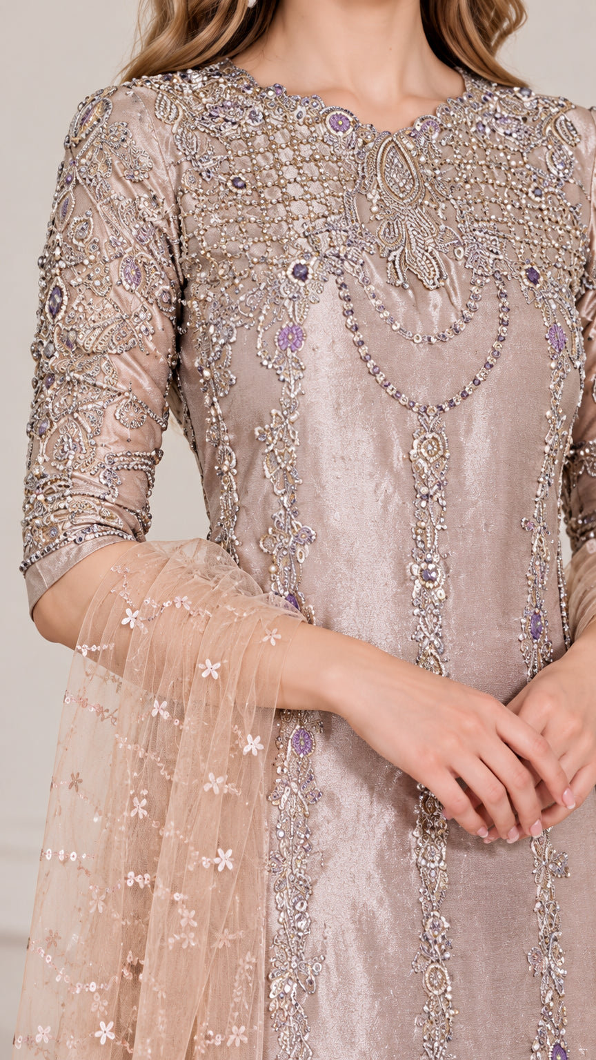 Close-up detail of intricate beading and embroidery on sheer tunic sleeves and neckline