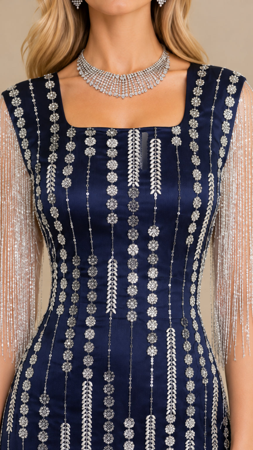 Close-up detail of silver-tone beading and fringe sleeve on navy blue evening dress