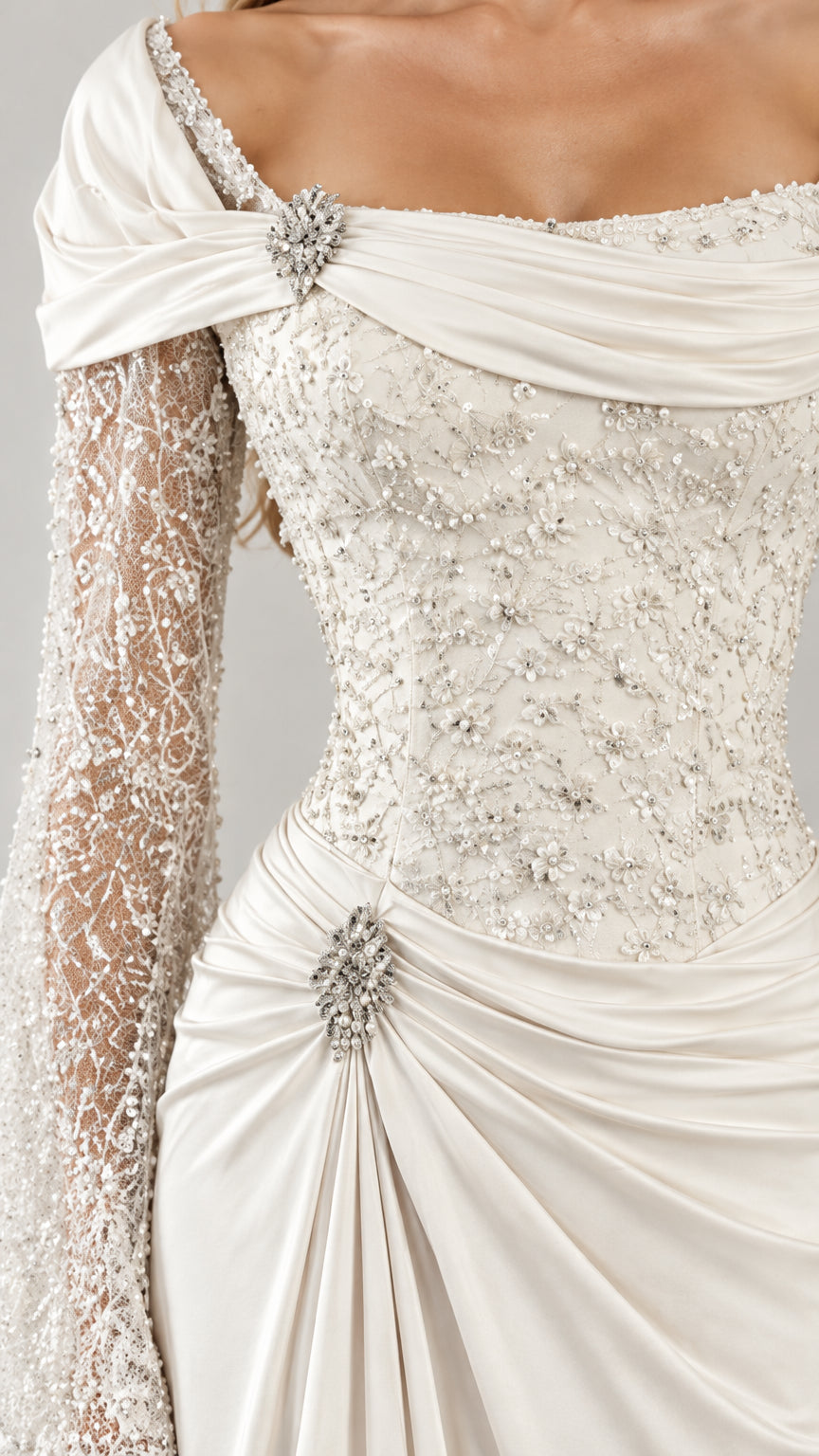 Close-up detail of crystal brooches, ruching, and beaded lace sleeves