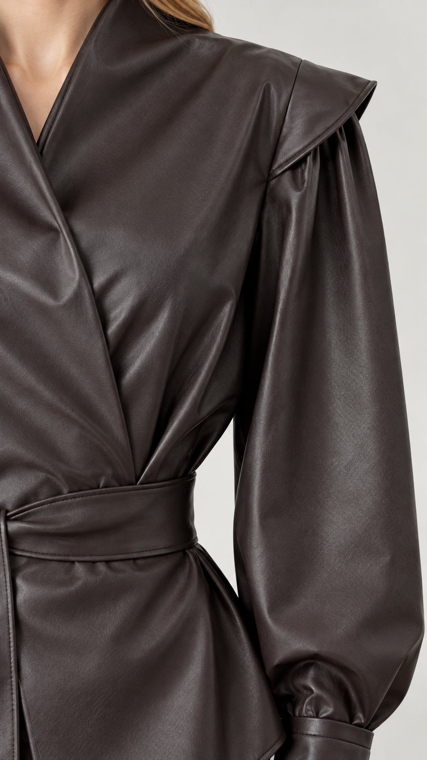 Close-up detail of dark brown faux leather shoulder flap overlay and wrap neckline