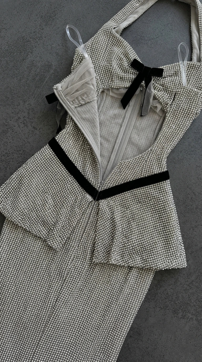 Flat lay close-up of silver glitter gown interior lining, zipper, and contrast bow detail