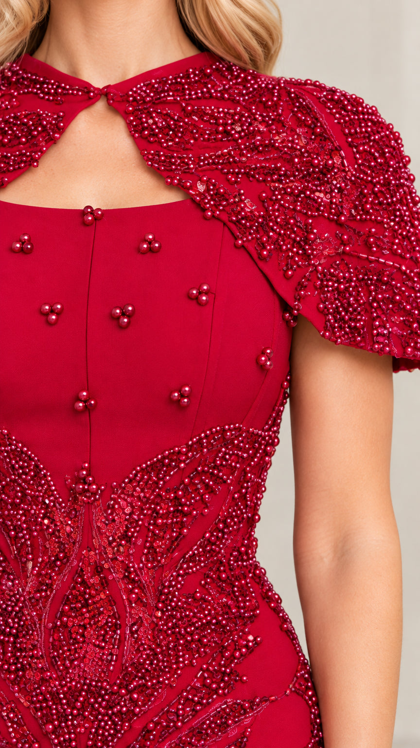 Close-up detail of red beaded capelet keyhole neckline and bodice embellishments