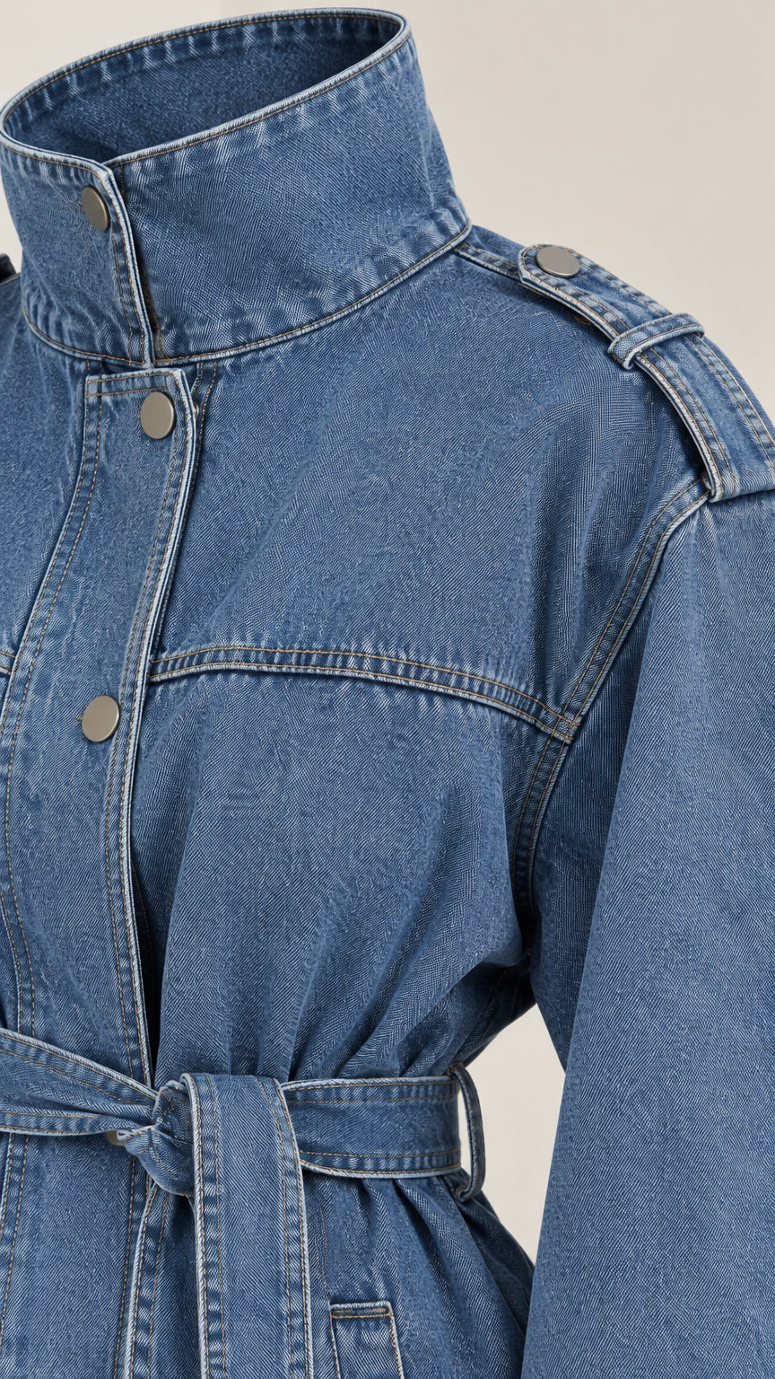 Close-up detail of denim blue stand collar, shoulder epaulettes, and snap front placket