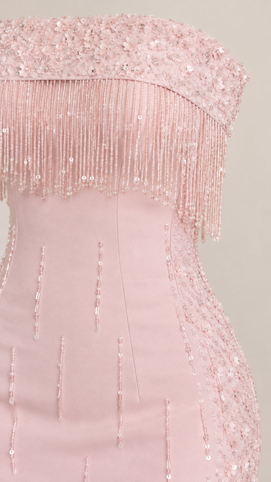 Close up of delicate beaded fringe and sequin detailing on blush pink bodice