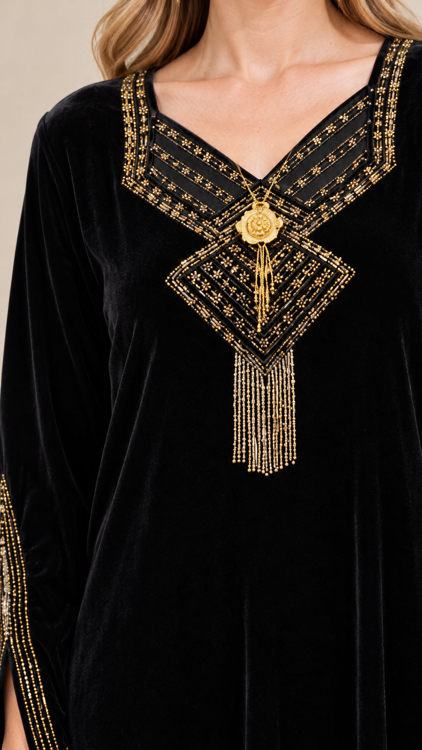 Close-up of intricate gold embroidered neckline with tassel detail on black velvet dress