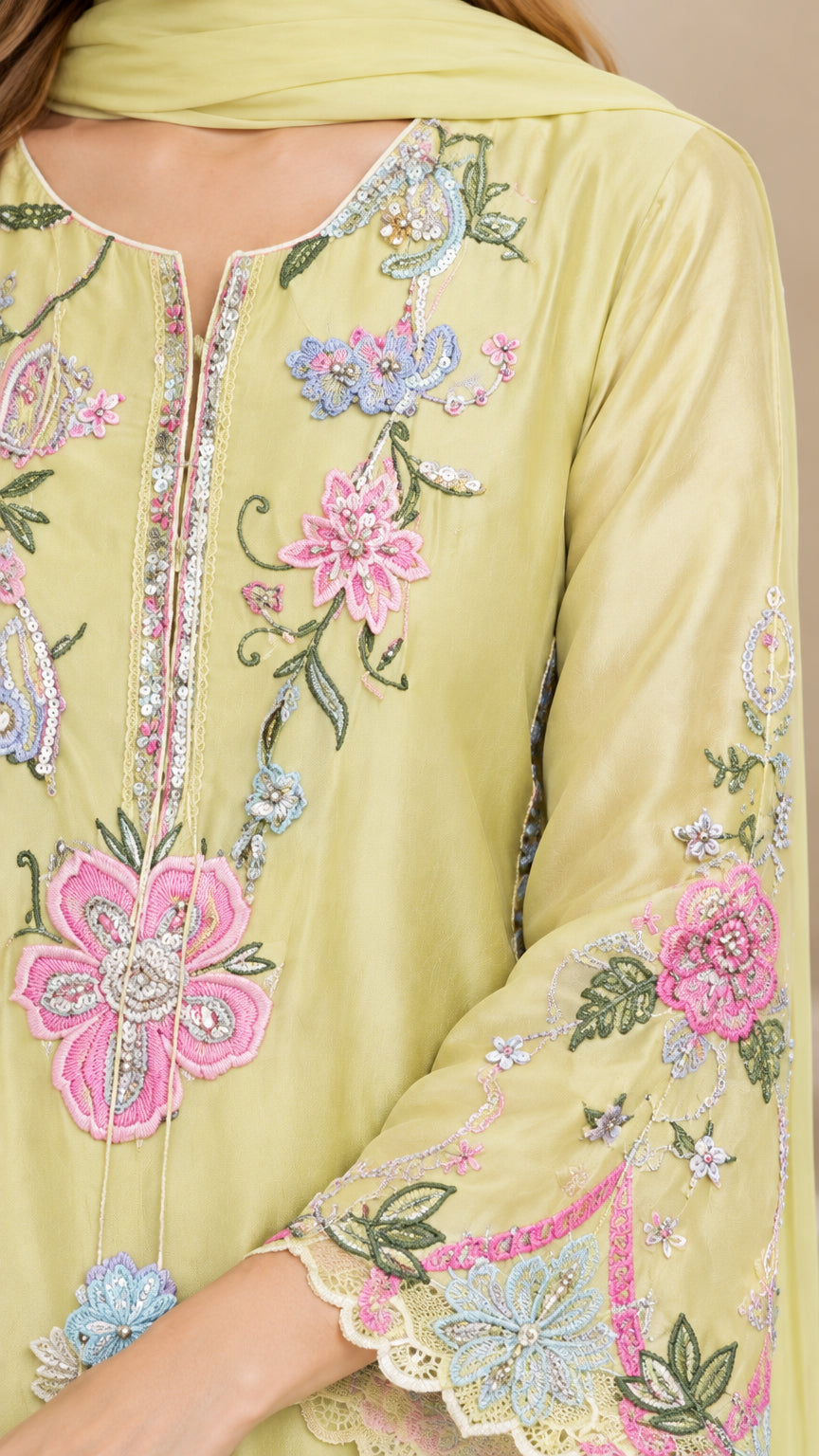 Close-up detail of floral embroidery and scalloped neckline on pistachio dress