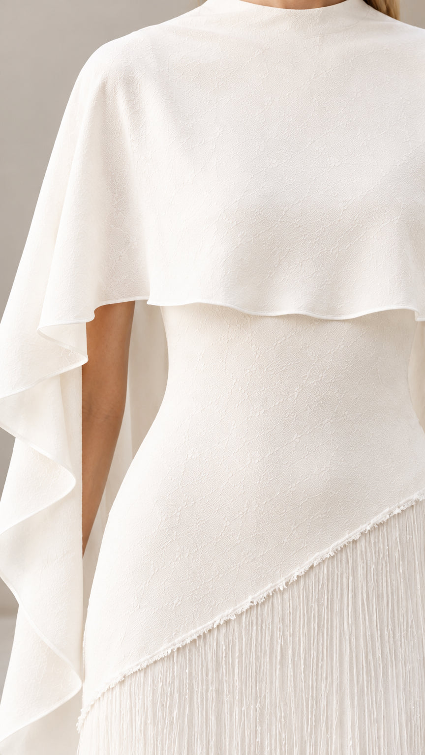 Close up of white mock neck and capelet overlay bodice detail