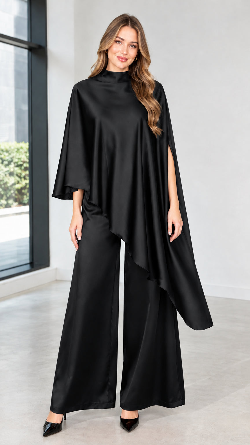Model wearing black satin asymmetrical cape top and wide-leg trousers two-piece set