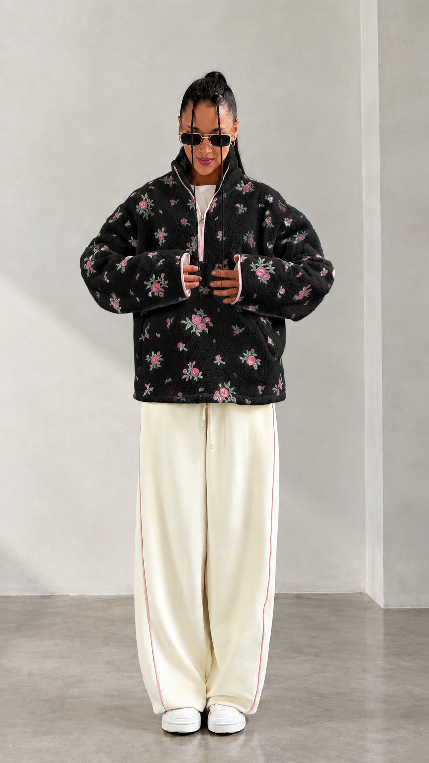 Front view of model wearing black floral print half-zip fleece pullover