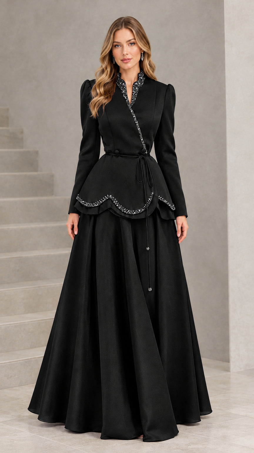 Front view of model in Black beaded peplum long sleeve evening gown