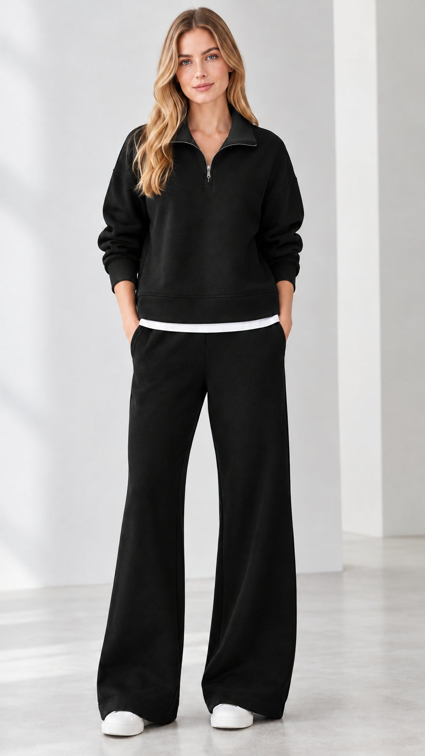 Front view of model wearing black half-zip sweatshirt and wide-leg pants set