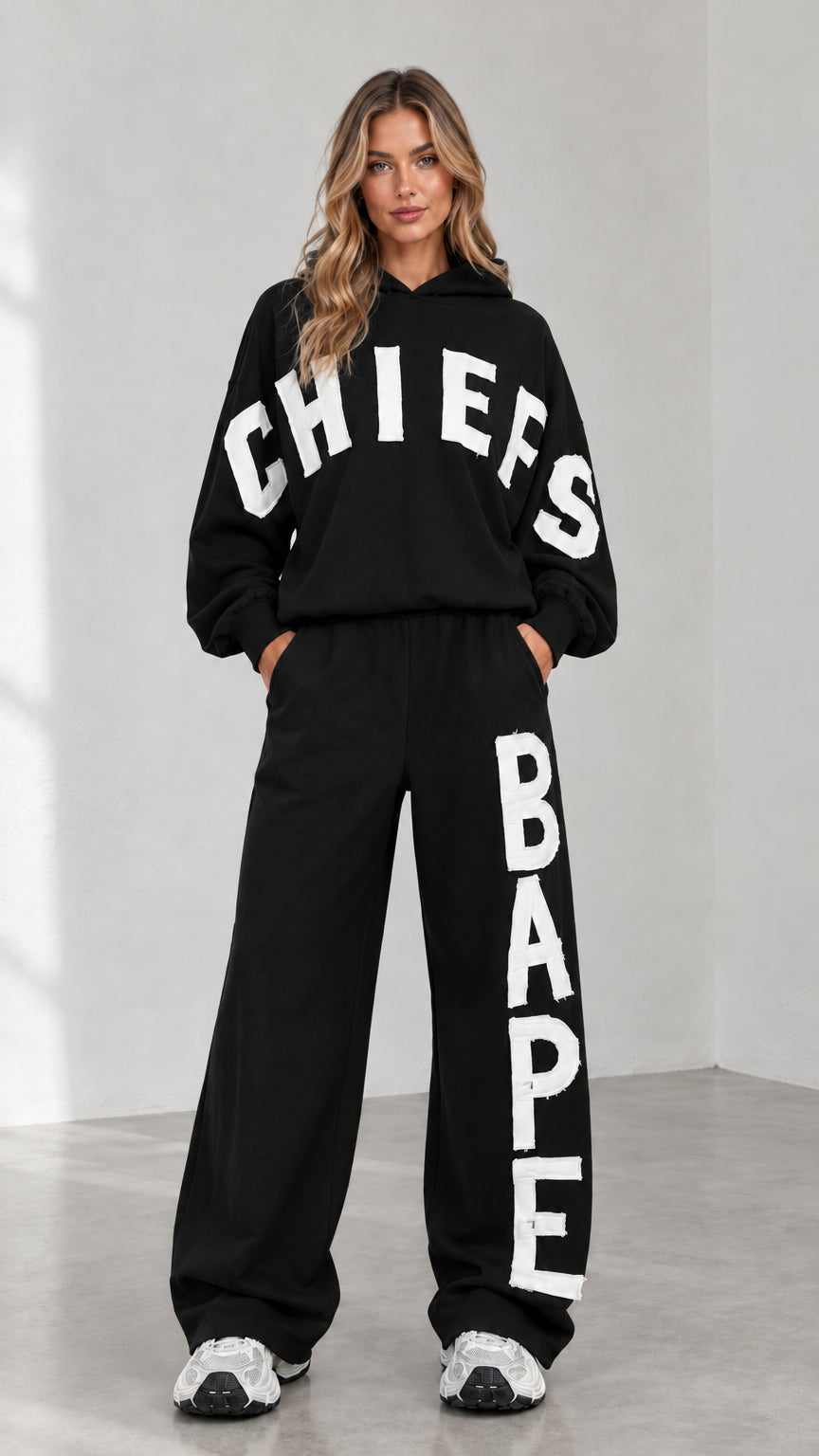 Full-body view of woman wearing black letter print oversized hoodie and sweatpants set