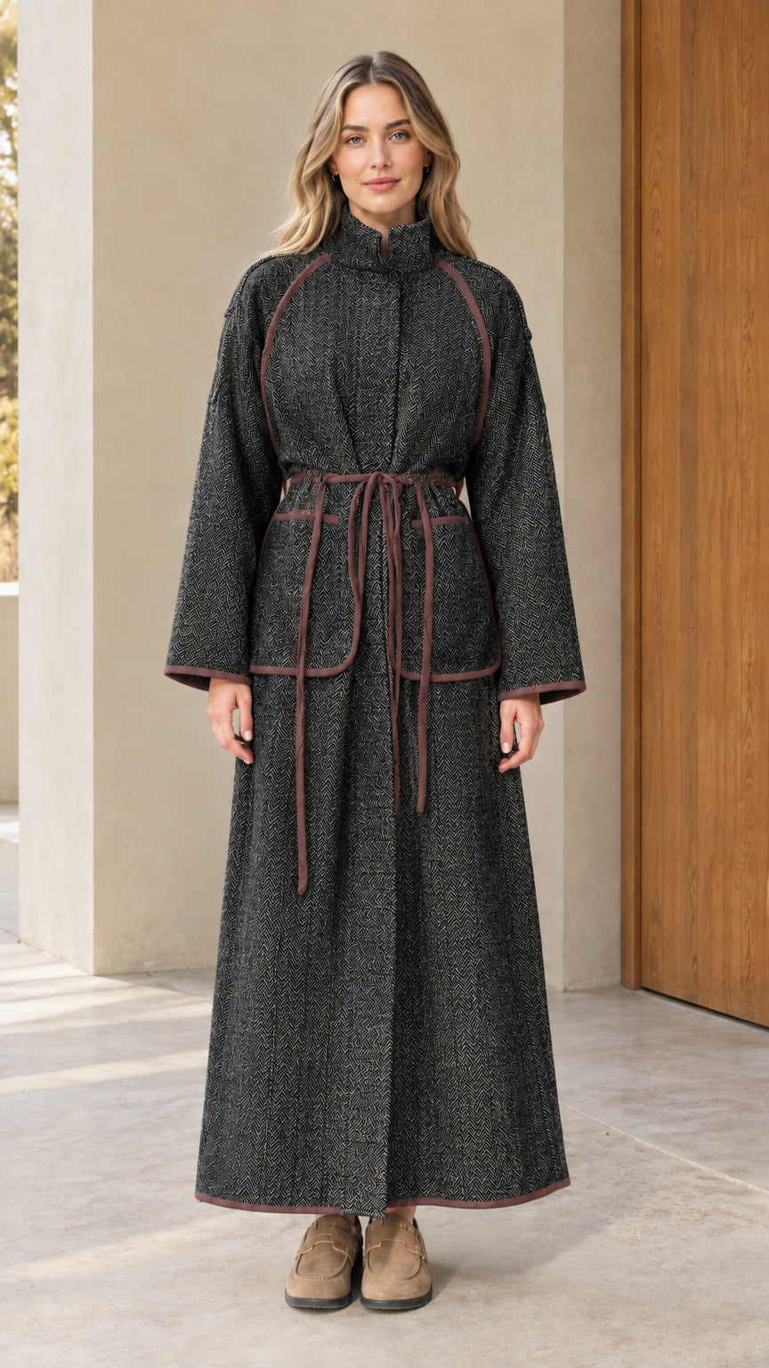 Full-length view of woman wearing charcoal black herringbone maxi coat