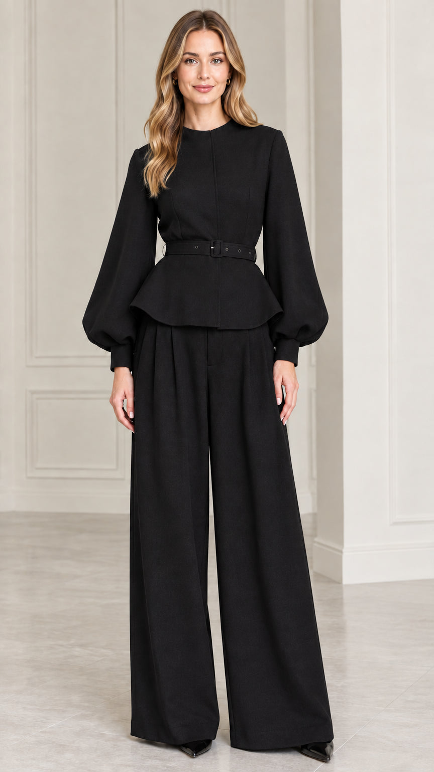 Full-length studio shot of model wearing Black belted peplum top and wide-leg pants set