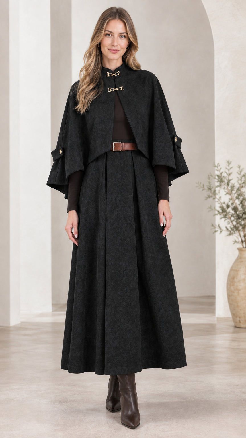 Front view of woman wearing Black cape and pleated maxi skirt set