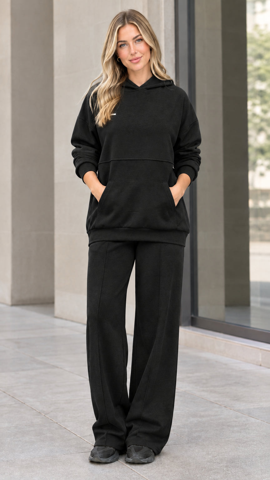 Front view of woman wearing black hoodie and wide-leg sweatpants matching set