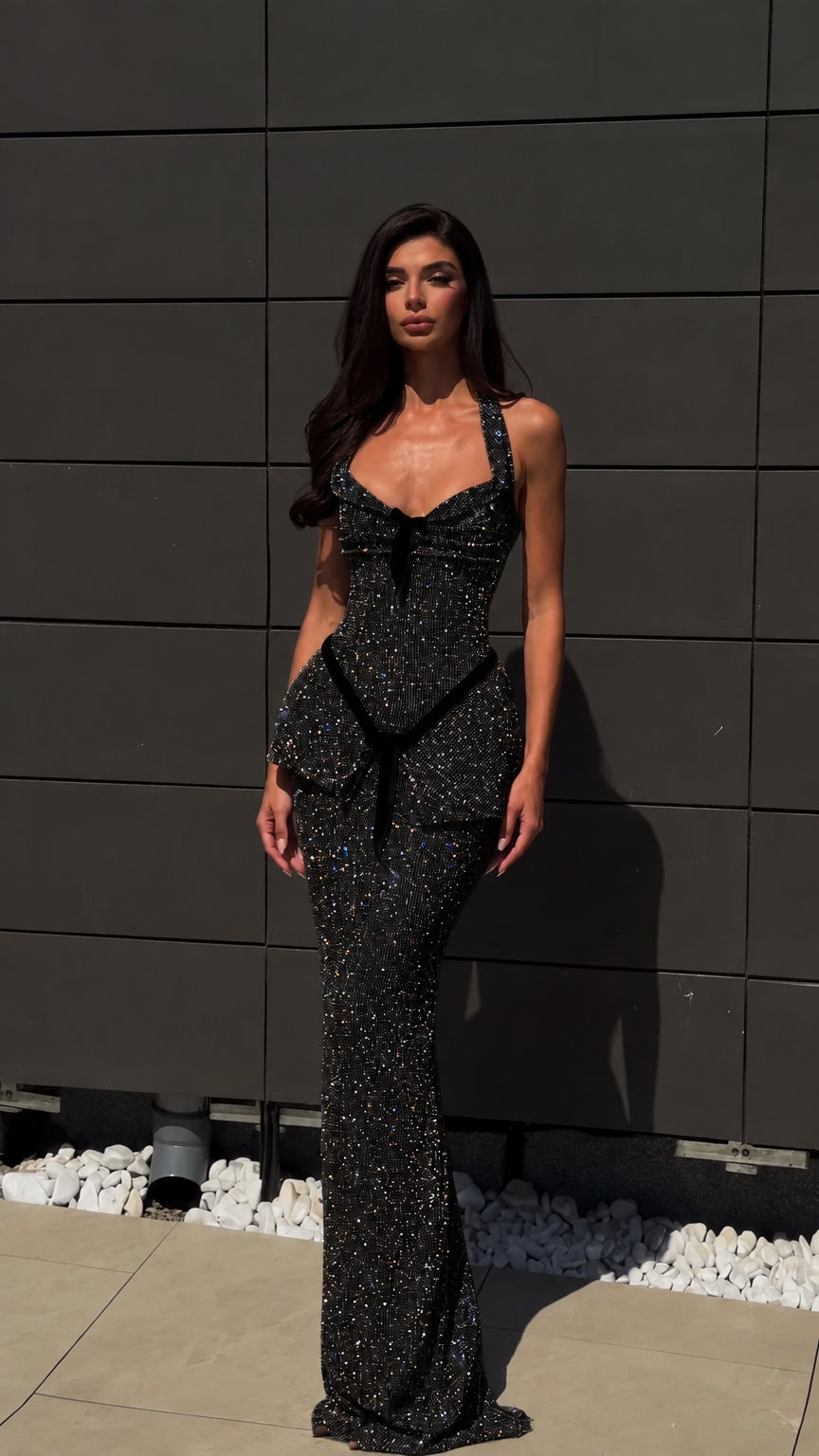 Model wearing black glitter halter peplum maxi evening gown