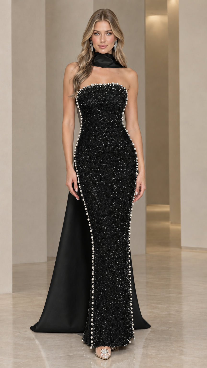 Model wearing black strapless sequin evening gown with matching black scarf cape