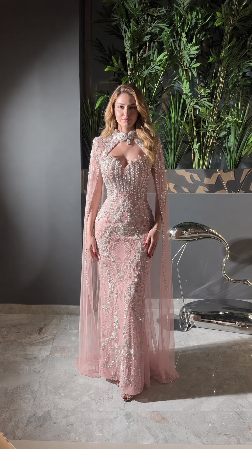 Front view of blush pink sequined evening gown with high neck cape design