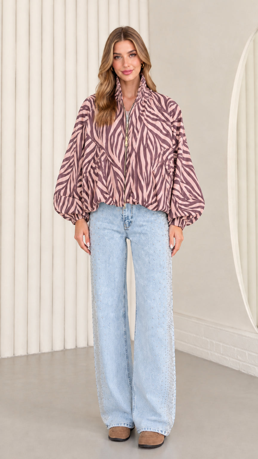 Model wearing mauve pink zebra print balloon sleeve jacket with light blue denim