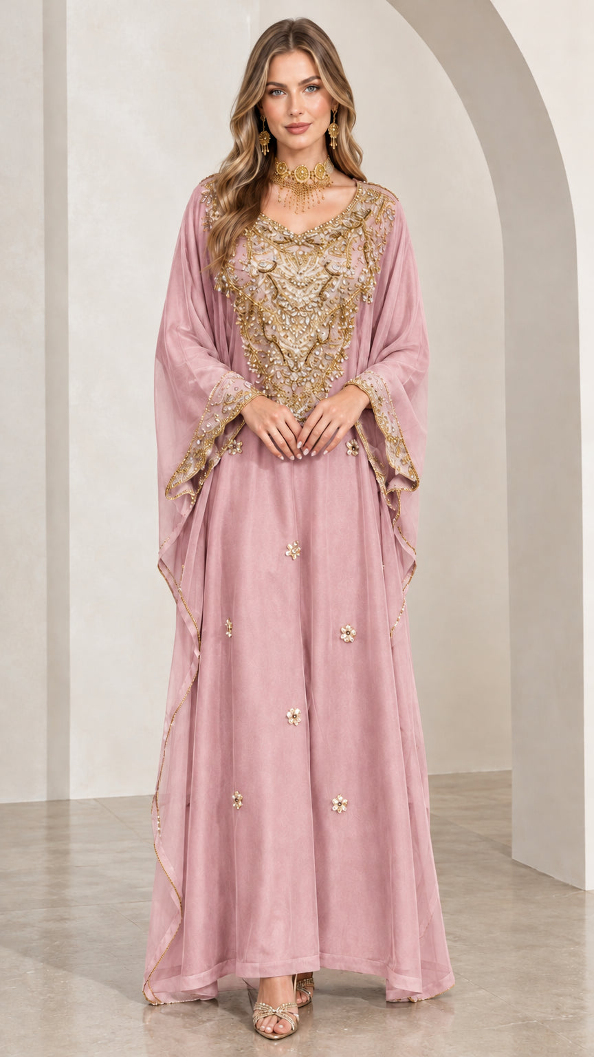 Woman wearing dusty pink kaftan maxi dress with gold beadwork