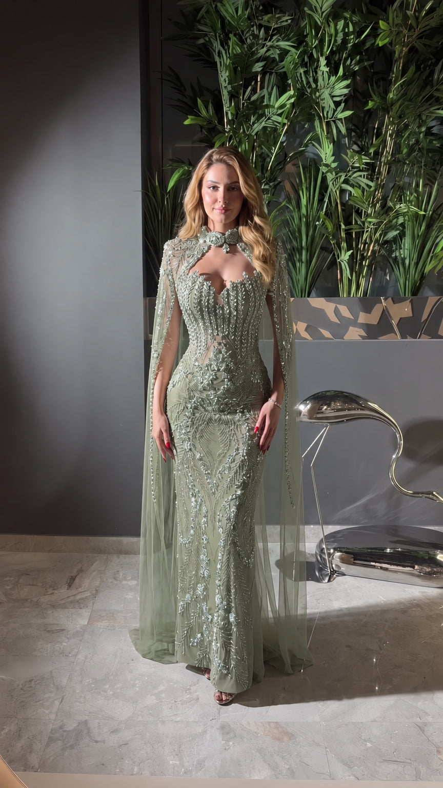 Front view of sage green beaded mermaid gown with attached tulle cape