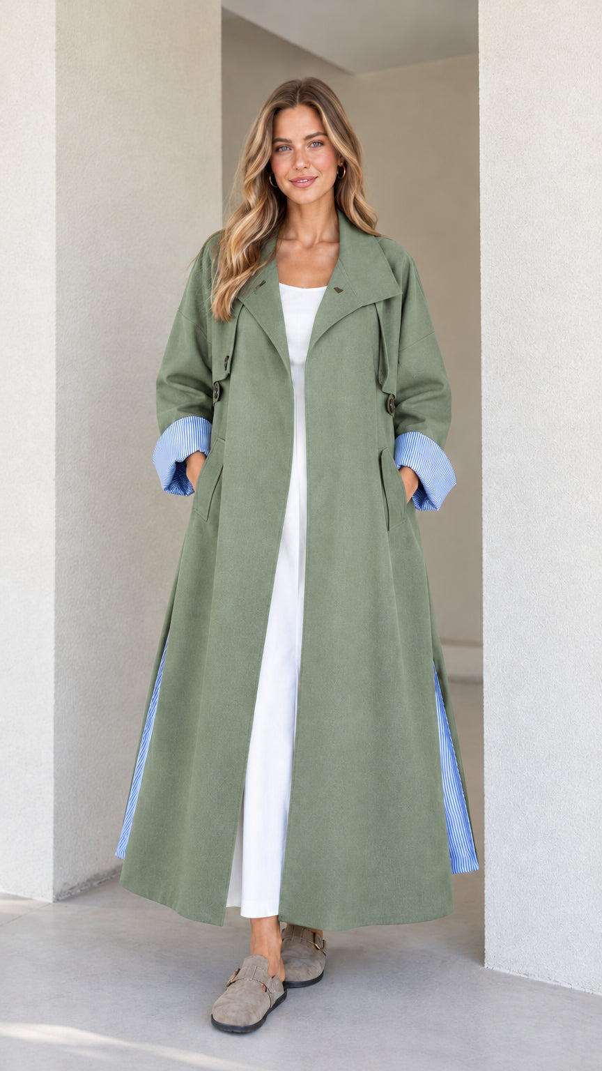 Model wearing the maxi trench duster in sage green with blue striped turn-up cuffs