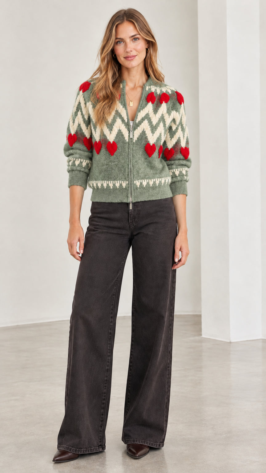Front view of woman wearing sage green chevron and red heart zip-up knit cardigan