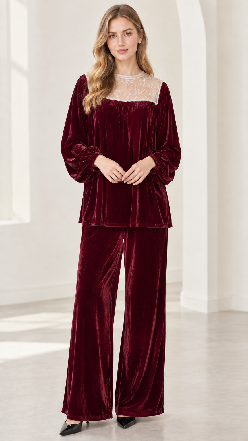 Full-length view of model wearing deep burgundy red velvet two-piece pant set