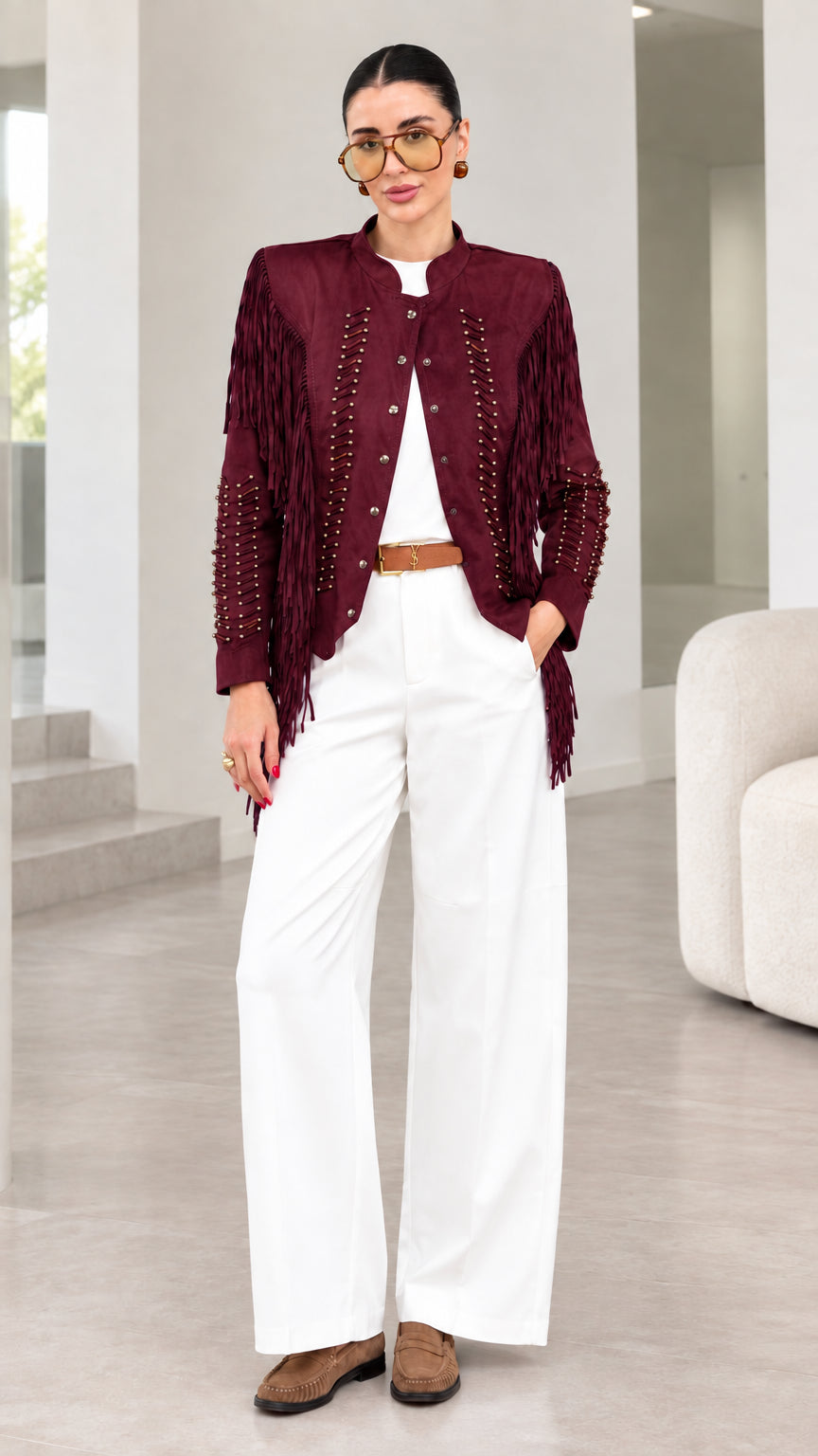 Model wearing burgundy red faux suede fringe jacket with white pants