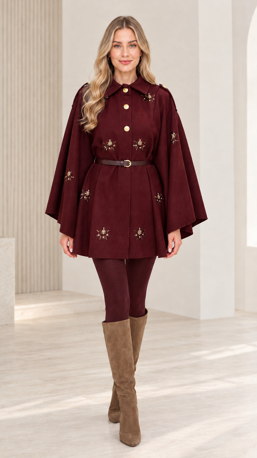 Front view of woman wearing burgundy embellished button-front belted cape coat