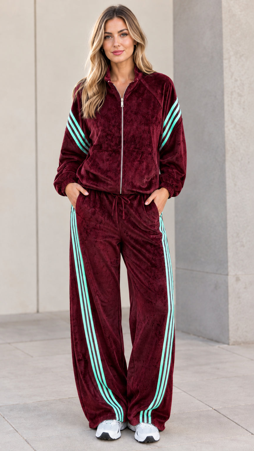Model wearing burgundy red velour tracksuit set with contrast stripes