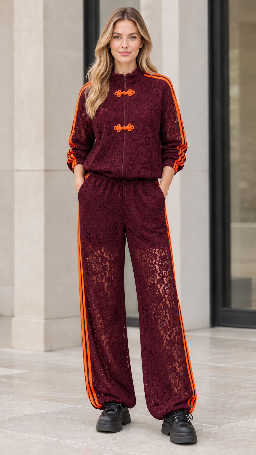Woman wearing burgundy floral lace tracksuit set with orange side stripes