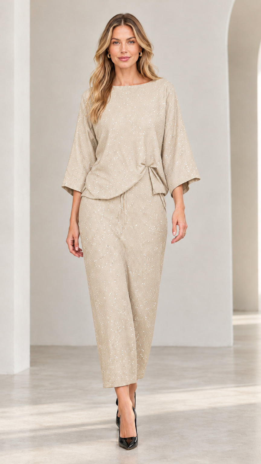 Model wearing champagne beige shimmer speckled two-piece top and matching pants