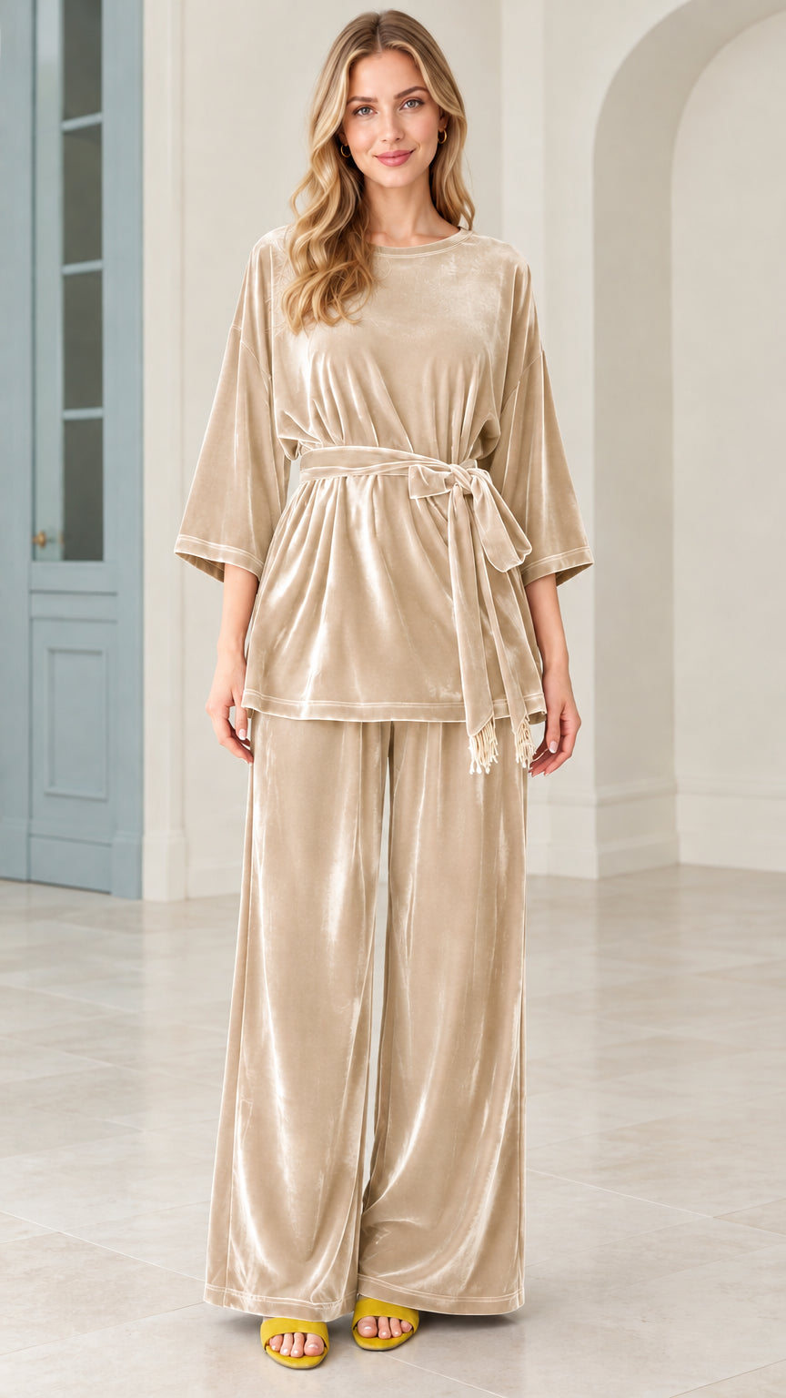 Model wearing champagne beige velvet belted top and wide leg pants matching set